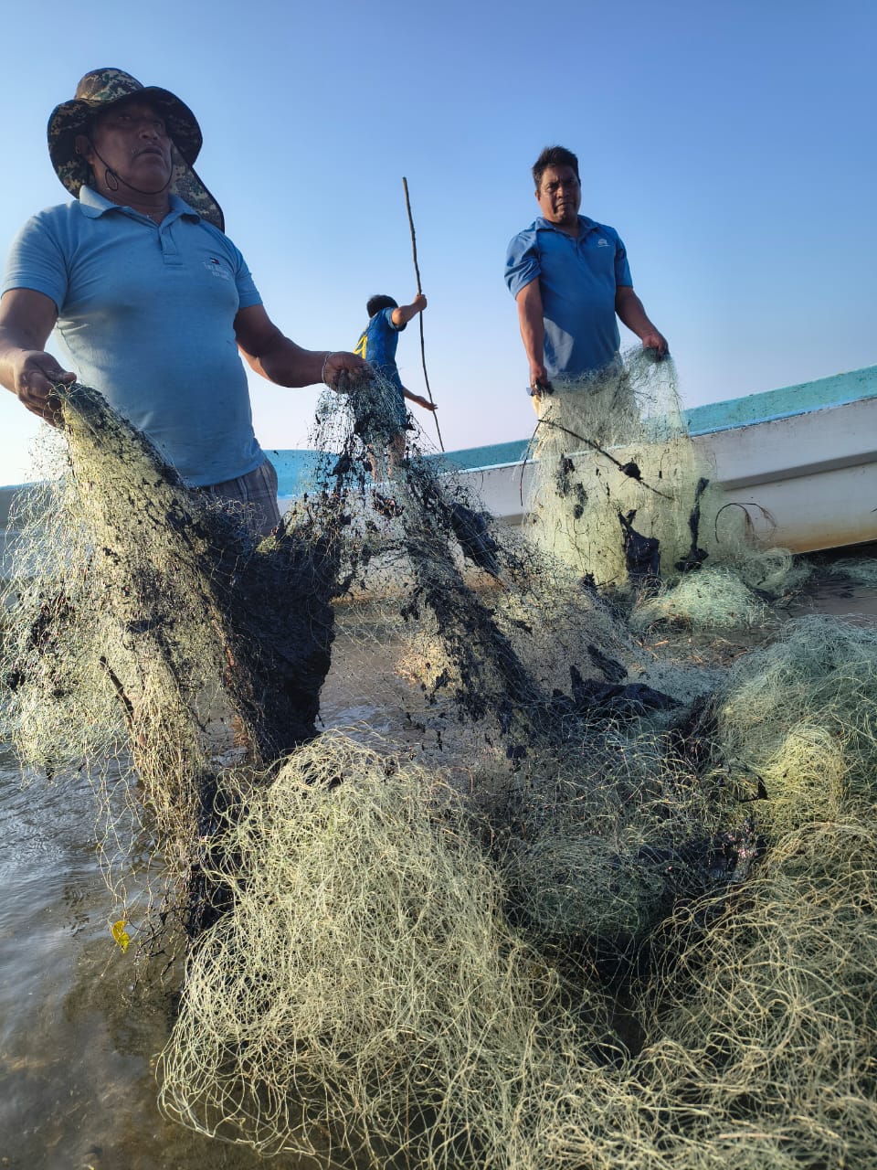 Pescadores con redes manchadas de petróleo