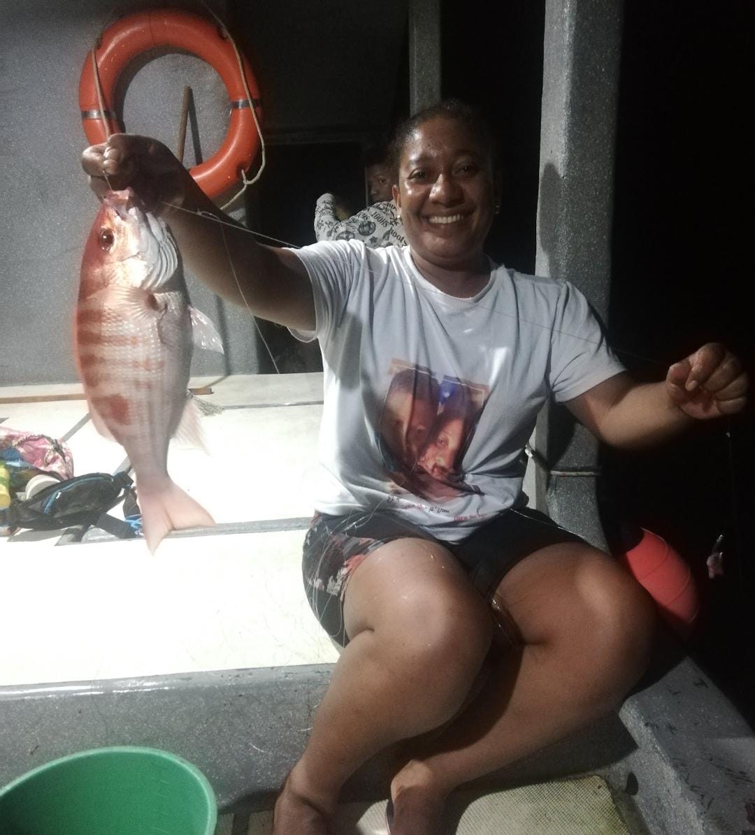 Pescadora con pez en línea de mano